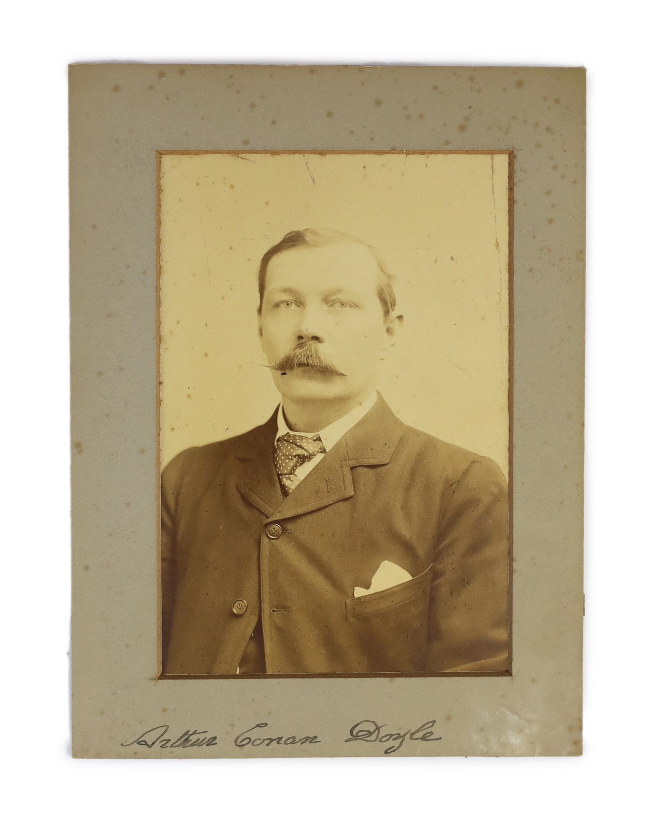 Doyle, Arthur Conan, Sir (1859-1930) a printed photograph, by Elliott and Fry, 55, Baker Street, London, signed on the mount, the signature probably added by Elliott and Fry 14 x 9.5cms